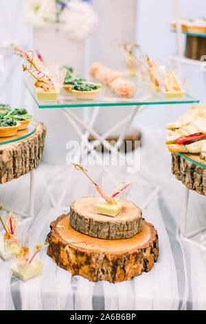 Mini canapes Essen. Das schön eingerichtete catering Bankett-, Holz- steht. Snacks und Vorspeisen. Hochzeitsfeier Stockfoto