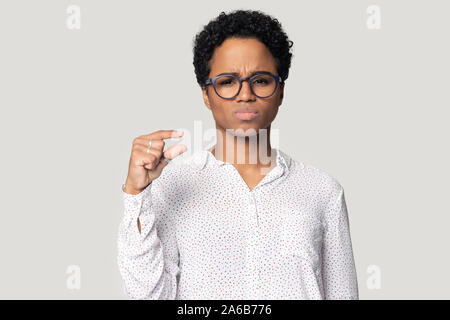 Kopf geschossen unglücklich Afrikanische amerikanische Frau zeigen wenig Größe Geste Stockfoto