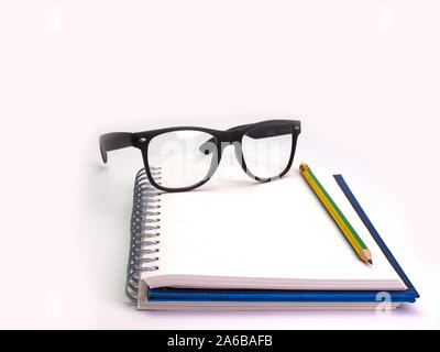 Bleistift, Buch und Brille, platziert auf einem weißen Hintergrund. (Platz für Ihren Text) Stockfoto