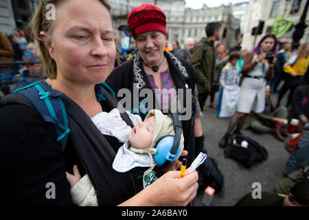 London, 10. Oktober 2019, eine Mutter mit ihrem Baby an Aussterben Rebellion Demonstration und Besetzung des Trafalgar Square. Stockfoto