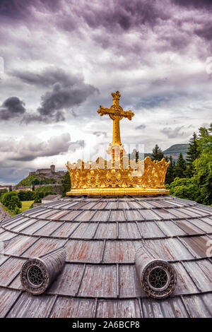 LOURDES - JUNI - 15 - 2019: christliche Kreuz auf einem Hintergrund der Basilika Unserer Lieben Frau vom Rosenkranz in Lourdes, Frankreich Stockfoto