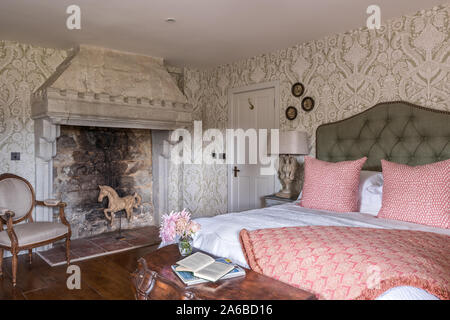 Im Art déco-Stil der 1930er Jahre Tapeten und alten Kamin aus Stein im Schlafzimmer. Stockfoto