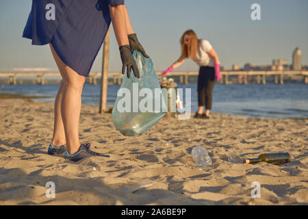 Sind eine Gruppe von Freiwilligen in schwarzen Handschuhe gehen mit Müllsäcken entlang ein schmutziges Wasser des Flusses und Reinigung, Abfall. Die Menschen und der Ökologie. Riv Stockfoto