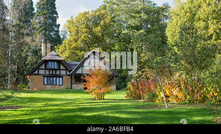 Reetdachhaus und Bäume im Herbst bei Batsford Arboretum, Cotswolds, Moreton-in-Marsh, Gloucestershire, England. Stockfoto