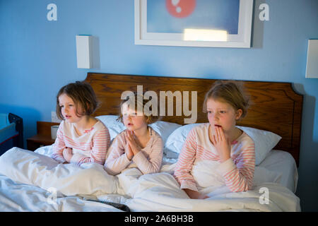 Drei Schwestern auf dem Bett im Schlafzimmer am Morgen Stockfotografie