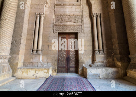 Externe Stil der alten Steine Steinwand mit Arabesque dekoriert Holztür von Stein gerahmt verzierten zylindrische Lichtmasten, die zu Al Rifai Moschee, alte Kairo, Ägypten Stockfoto