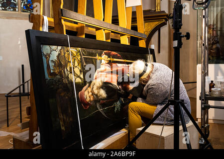 Colmar, Frankreich. 25 Okt, 2019. Eine Restauratorin arbeitet auf einem Panel der Isenheimer Altar in der Unterlinden. Der Altar wird derzeit umfassend saniert werden. Quelle: dpa Picture alliance/Alamy leben Nachrichten Stockfoto