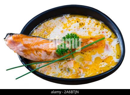 Schale, cremige Suppe mit Lachs, Käse und Gemüse garniert mit frischen Grüns. Auf weissem Hintergrund Stockfoto