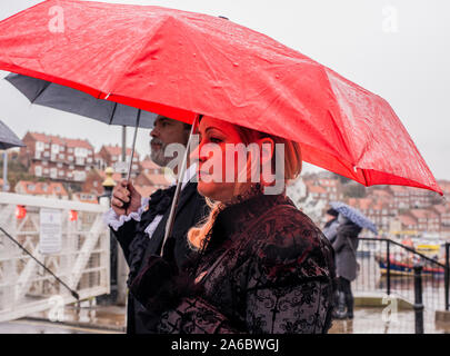 Goth Paar in traditionellen Kostümen im Regen stehend, Whitby Goth Wochenende Festival, Whitby, North Yorkshire, UK, 25. Oktober 2019 Stockfoto