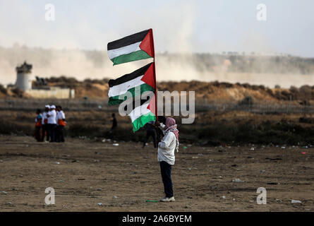 Gaza, Palästina. 25 Okt, 2019. Eine Demonstrantin hält palästinensische Fahnen bei Auseinandersetzungen mit israelischen Truppen in der Nähe des südlichen Gazastreifen Stadt von Khan Younis, Okt. 25, 2019. Credit: Yasser Qudih/Xinhua/Alamy leben Nachrichten Stockfoto