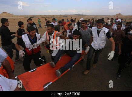 Gaza, Palästina. 25 Okt, 2019. Palästinensische Ärzte helfen einem Menschen bei Auseinandersetzungen mit israelischen Truppen in der Nähe des südlichen Gazastreifen Stadt von Khan Younis, Okt. 25, 2019 verwundet. Credit: Yasser Qudih/Xinhua/Alamy leben Nachrichten Stockfoto
