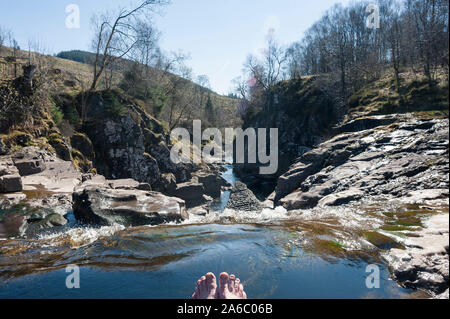 Zehen in das Wasser eines frischen und getaucht Kalter schottischer Bach / Bach / Bach Stockfoto