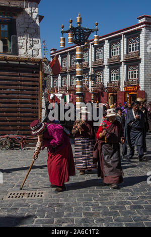 Ältere tibetische Frauen in traditioneller Kleidung umrunden den Jokhang Tempel Kora oder Schaltkreis mit ihren beten Räder in Lhasa, Tibet. Stockfoto