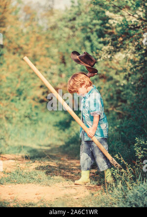 Kleine Helfer im Garten arbeiten. Niedliche Kind in der Natur Spaß mit Schaufel. Ich schätze zu finden. Glückliche Kindheit. Abenteuer auf der Jagd nach Schätzen. Kleiner Junge mit Schaufel auf der Suche nach Schätzen. Stockfoto