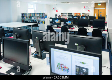 Einer Universität oder einem College Bibliothek mit Büchern in den Regalen, Studenten und Computer Stockfoto