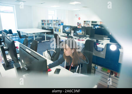 Einer Universität oder einem College Bibliothek mit Büchern in den Regalen, Studenten und Computer Stockfoto
