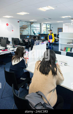 Einer Universität oder einem College Bibliothek mit Büchern in den Regalen, Studenten und Computer Stockfoto