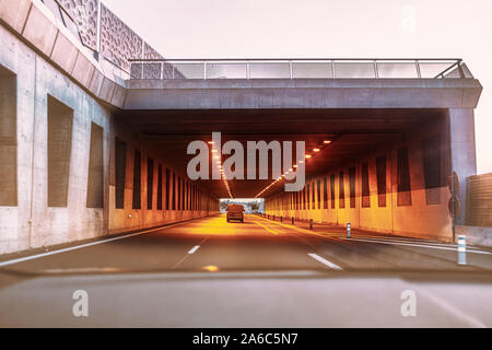 In einen Tunnel auf der Autobahn nach einem Transit van. Der tunnel mit orange Leuchten ist, nehmen Sie die Ausfahrt gesehen werden kann. Stockfoto