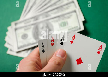 Hand hält vier Asse auf grünem Hintergrund. Close Up. Stockfoto