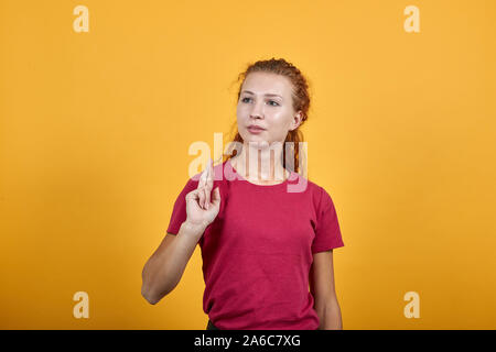 Hübsche Frau auf der rechten Seite schauen, kreuzte ihre zwei Finger an der rechten Hand. Stockfoto