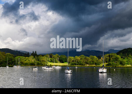 Segelboote vertäut am Lake Windermere am Waterhead Ambleside in Morgensonne mit dunklen Wolken Lake District National Park England Stockfoto