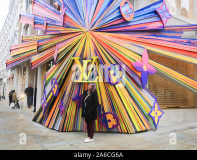 Eine touristische posiert vor Der neu renovierten Louis Vuitton Flagship Store in New Bond Street eröffnet wurde. Stockfoto