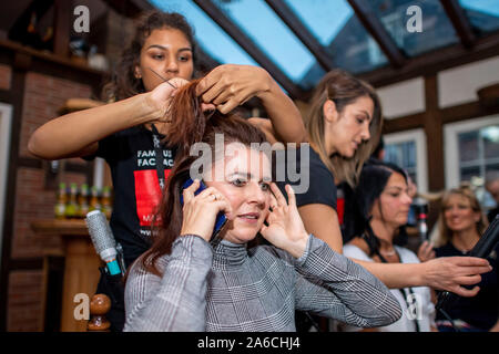 Harsewinkel, Deutschland. 25 Okt, 2019. Ein Make-up Artist von Styles Das Haar der Teilnehmer Annette Sensener. 20 Finalisten im Wettbewerb um den Titel des 'Miss 50 plus". Quelle: David Inderlied/dpa/Alamy leben Nachrichten Stockfoto