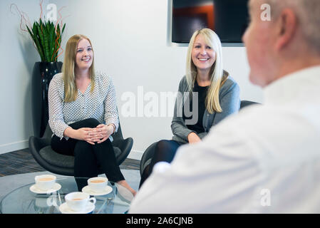 Zwei Frauen sprechen Sie mit Ihrem Manager in einem informellen Treffen mit Kaffee Stockfoto