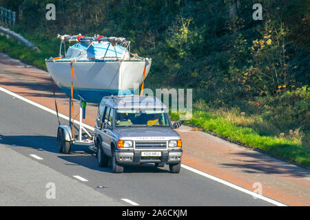 Großer Yacht-Rumpf auf Bootstransportanhänger, 2001 Land Rover Discovery Td5 GS Saloon Cars, Schleppen Yacht-Anhänger in südlicher Richtung auf der dreispurigen Autobahn M6. Stockfoto