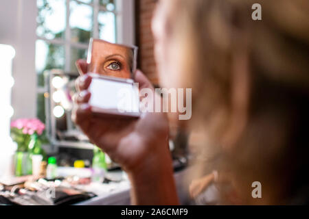 Harsewinkel, Deutschland. 25 Okt, 2019. Nicole Wittner schaut sie Auge in einem Spiegel. 20 Finalisten im Wettbewerb um den Titel des 'Miss 50 plus". Quelle: David Inderlied/dpa/Alamy leben Nachrichten Stockfoto