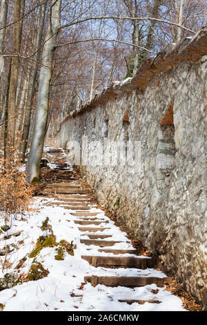 Ein schneebedeckter Fußweg entlang der befestigten Mauern auf Kapzinerberg, einem Hügel in Salzburg, Österreich. Stockfoto