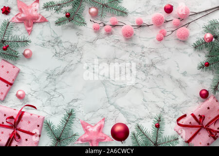Weihnachten flach mit Rahmen aus verpackte Geschenkboxen, natürlichen, grünen Tannen Zweigen und dunklem Rot und Rosa Trinkets. Kopieren - Platz für Ihren Text. Stockfoto