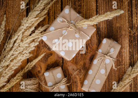 Geschenk oder präsent Boxen in Handwerk Papier mit Dekorationen auf Holz- Hintergrund gewickelt. Flach, kopieren. Stockfoto