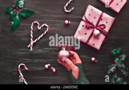 Festliche dunkle Weihnachten Hintergrund mit rosa Geschenkboxen, gestreifte Zuckerstangen in Form der Herzen, Schmuckstücke und dekorative Sterne, kreative Flach mit X Stockfoto