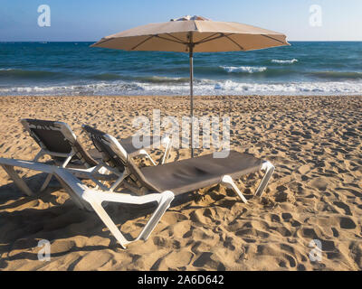 Liegestühle und Sonnenschirme auf dem Ozean. Travel Concept entspannen. Leeren Strand Seite. Stockfoto