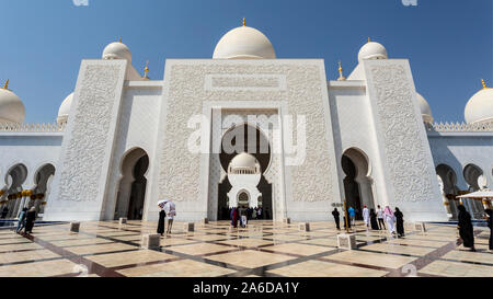 Blick auf den herrlichen Haupteingang mit atemberaubenden Designs geschnitzt in der weiße Marmor einschließlich anic Text des Qur'an, in der Sheikh Zayed Grand Moschee in Stockfoto