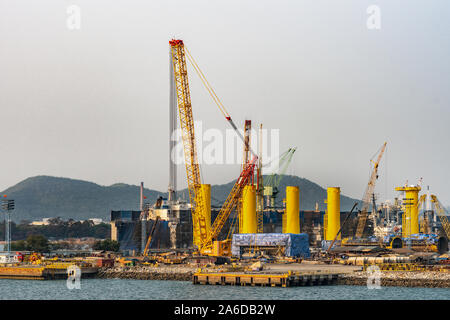 Laem Chabang Seehafen, Thailand - 17. März 2019: hohe Kräne Kräne und Metall Zylinder zusammen mit einem chaotischen Szene der Baustelle für eine l Stockfoto