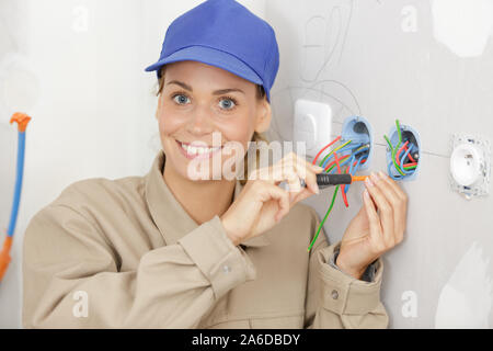 Weibliche Elektriker Drähte im Sockel Stockfoto