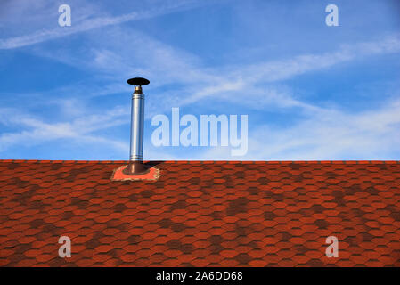 Metall Schornstein auf dem Dach mit Bituminösen flexible Fliesen Beschichtung auf dem Hintergrund des blauen Himmels Stockfoto
