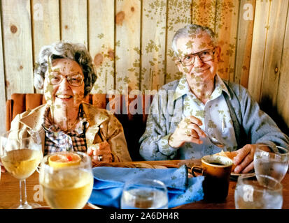 Unregelmäßige grünliche Flecken von Schimmel auf einen Farbfilm Transparenz verursacht haben dieses Bild eines älteren amerikanischen Paar genießen Sie eine Mahlzeit in einem Restaurant während auf Ferien in 1980 ruiniert. Die Ursache von Schimmel auf Fotografien erscheinen im Laufe der Zeit ist oft ein Geheimnis. Es können häufig vor übermäßiger Feuchtigkeit oder Wärme, wo die Bilder gespeichert wurden. Im Hinblick auf dieses Bild, das Schimmel verursacht wurden durch die Auswaschung von Chemikalien aus der Kunststoffhülle, in der die Kodak Ektachrome 35 mm Folie gehalten wurde. Eine andere mögliche Ursache für Schimmel auf Fotos ist fehlerhafte Verarbeitung. Stockfoto