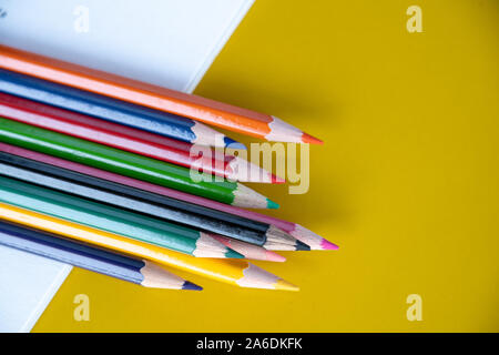 Bunte Zeichenstifte auf gelbem Hintergrund Stockfoto