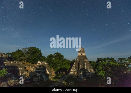 Tempel I, Tempel der Jaguar und der Nord-Akropolis durch das Licht des Vollmondes nachts mit Sternenhimmel, Tikal National Park, Guatemala. Stockfoto