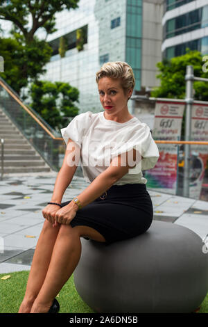 Porträt einer zuversichtlich, kurzes Haar Kaukasischen business Frau in weißer Bluse, schwarzer Rock posiert Garten im Freien. Leere Platz für Text. Stockfoto