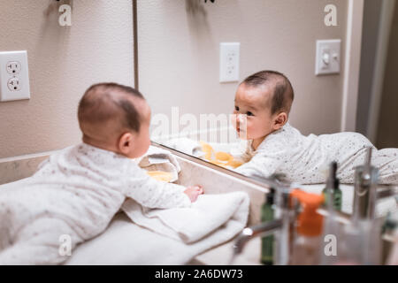 Adorable 5 Monate alten asiatischen baby boy sehen selbst im Badezimmer Spiegel zu Hause