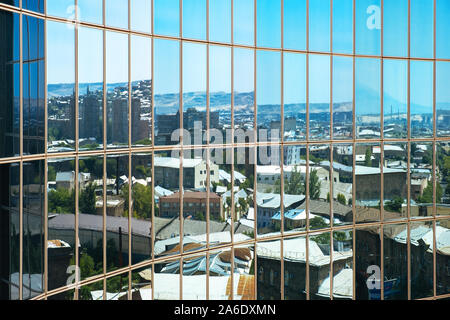 Reflexion der Stadt in einem Gebäude aus Glas Stockfoto