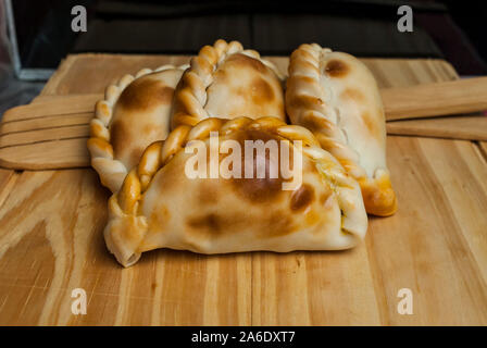 Holztisch mit frischen, hausgemachten Empanadas (detaillierte Nahaufnahme; selektive Fokus) Stockfoto