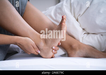 Frau Gefühl Achillesferse Schmerzen im Bett Stockfoto