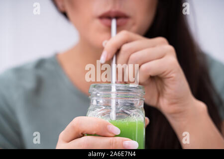 Frau trinkt Bio Smoothie mit Metall Stroh Stockfoto