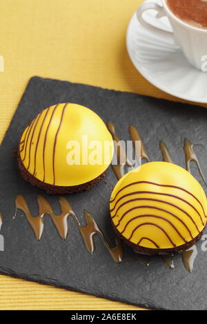 Schwedische Prinzessin Kuchen mit Mango Marshmallow auf Schokoladenscheibe mit Schokoladeneisung Stockfoto