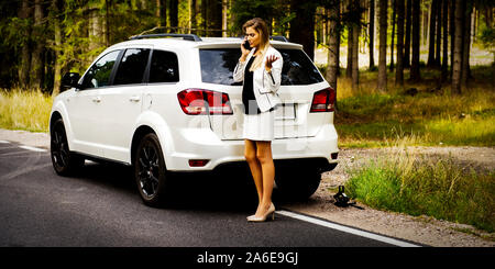 Business woman erwischt einen platten Reifen und Auto Hilfe. Auto Versicherung. Stockfoto